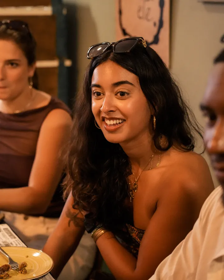 Guests smiling around a dinner table